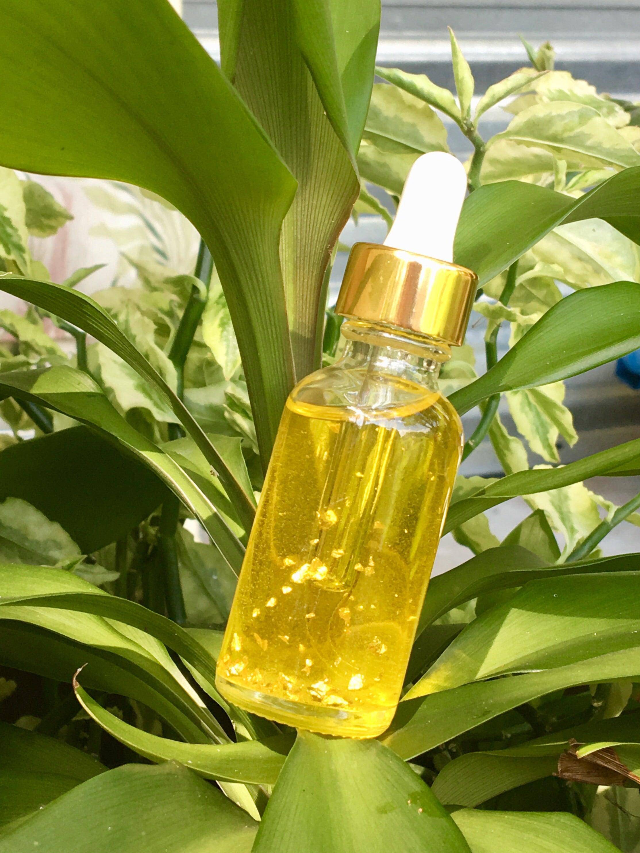 Bottle of House Of Beauty by Paris J 24k Gold Flake Serum for skin care, featuring a sleek design with gold flakes inside.
